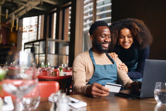 business owners looking at their business savings account on computer