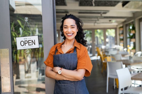 happy woman business owner in front of shop