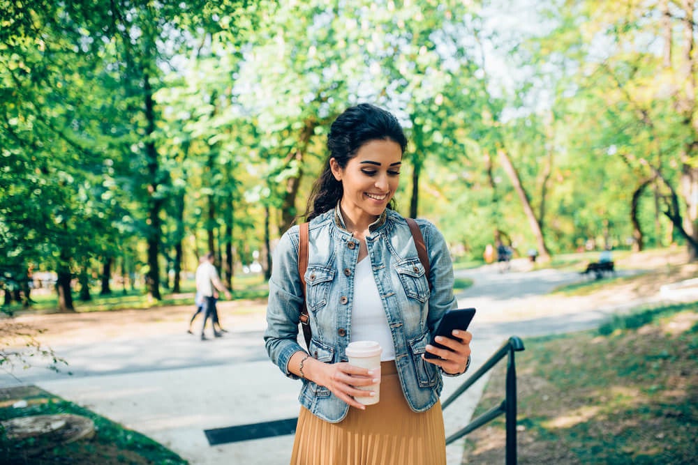 college student checking bank account with a smile of her face