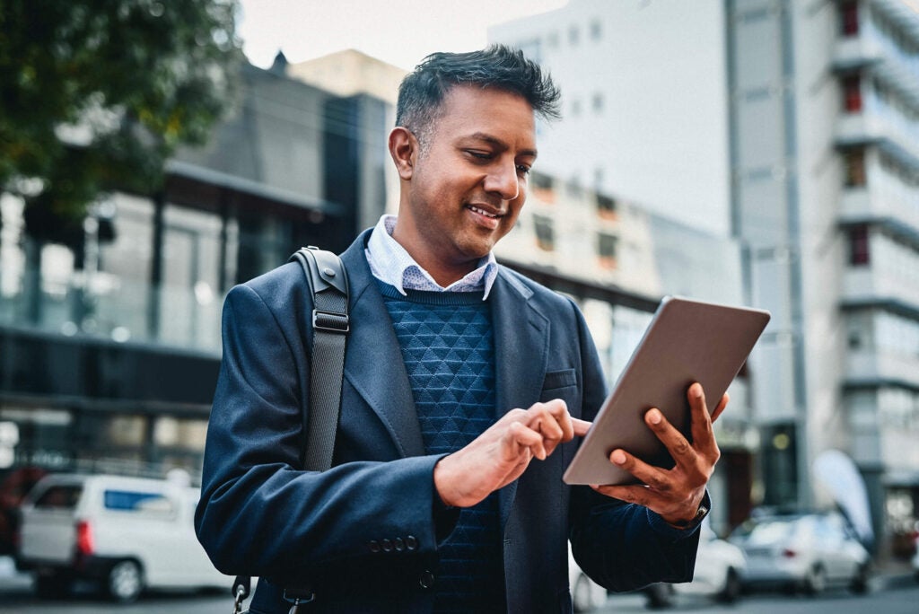 man looking at tablet outside banking