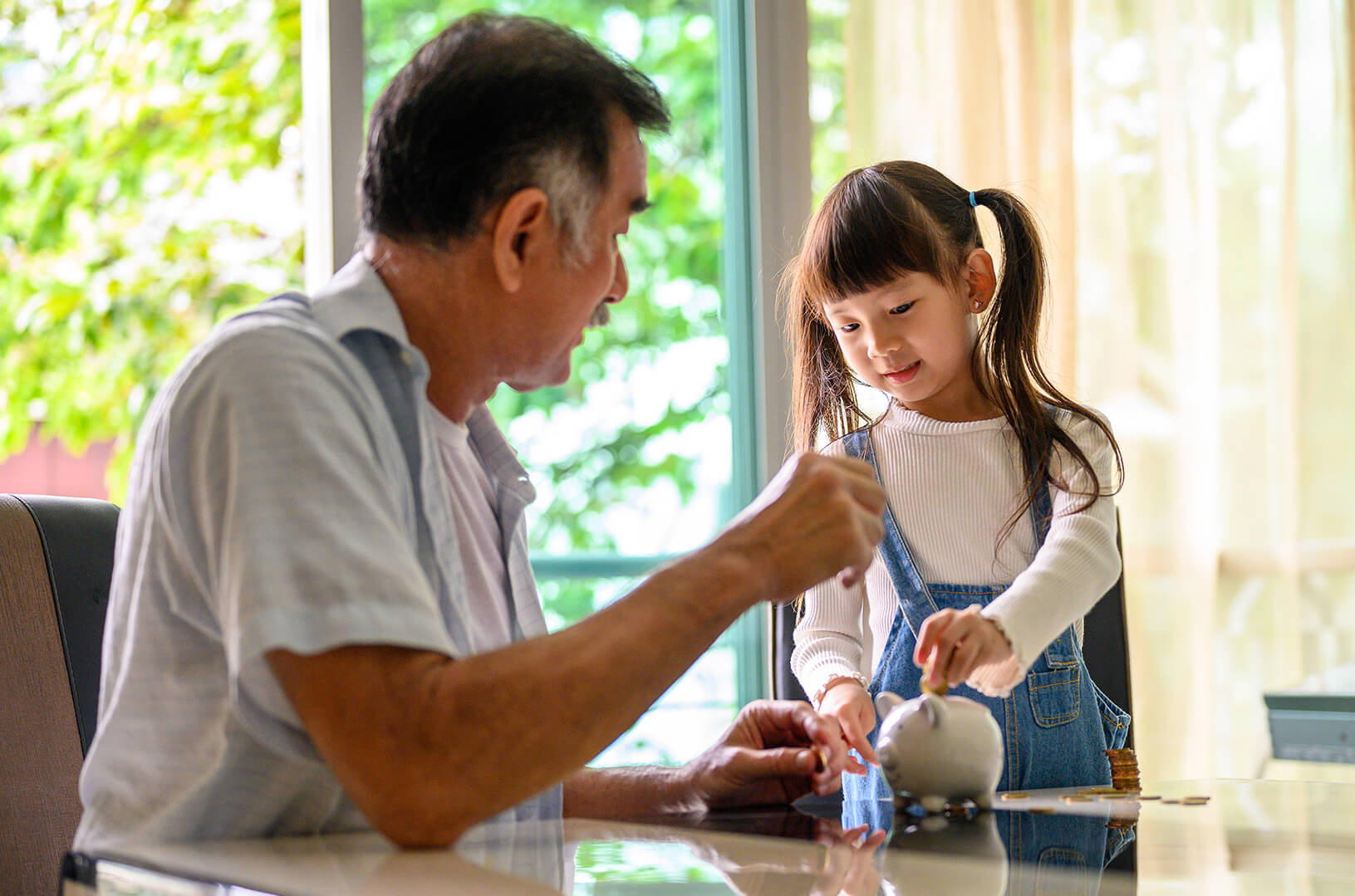 Granfather showing child how to save allowance