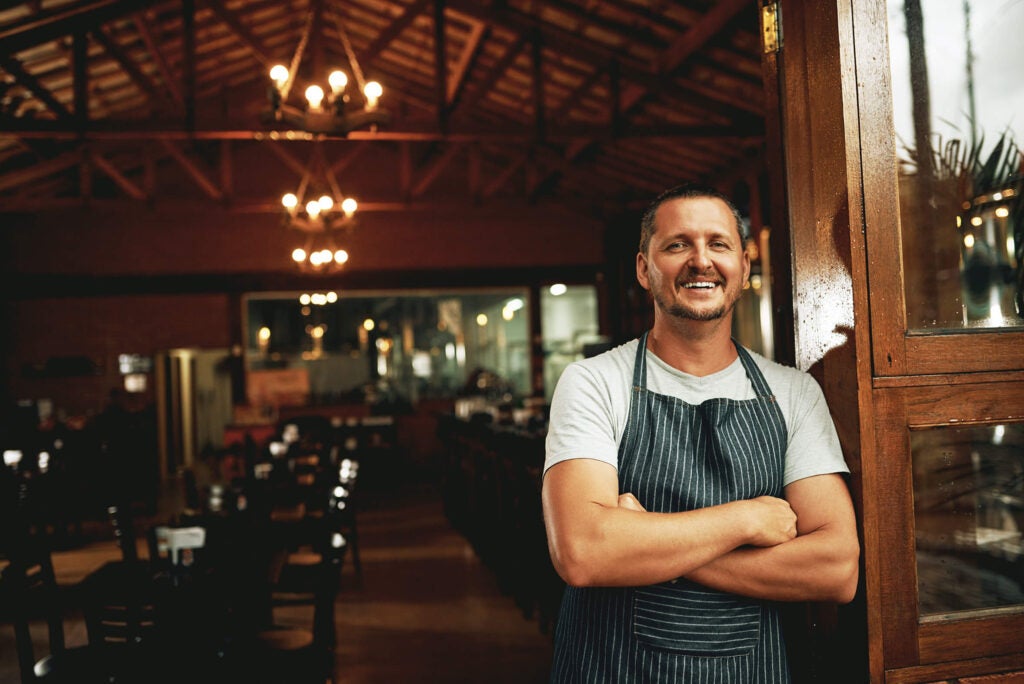 Restaurant owner happy and standing at entrance