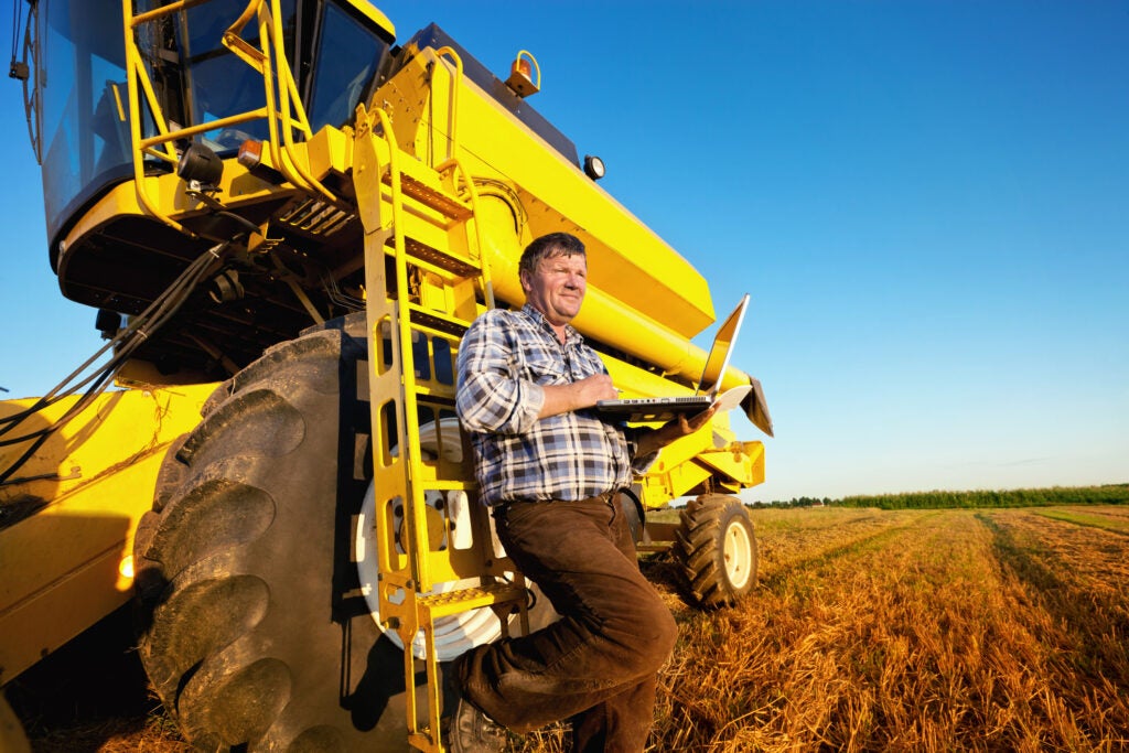 farmer looking at equipment loan on his laptop