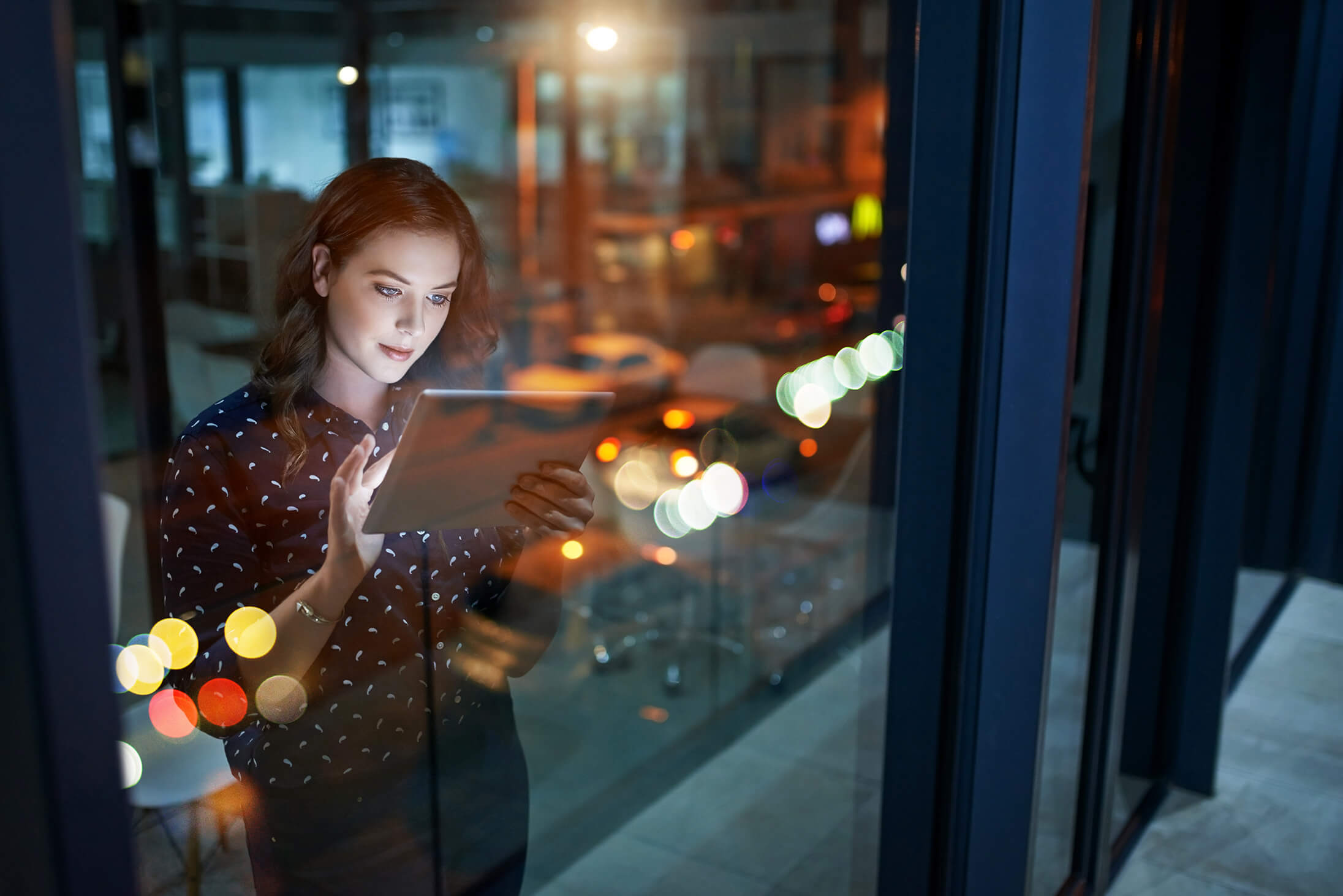 woman working late inspecting tablet