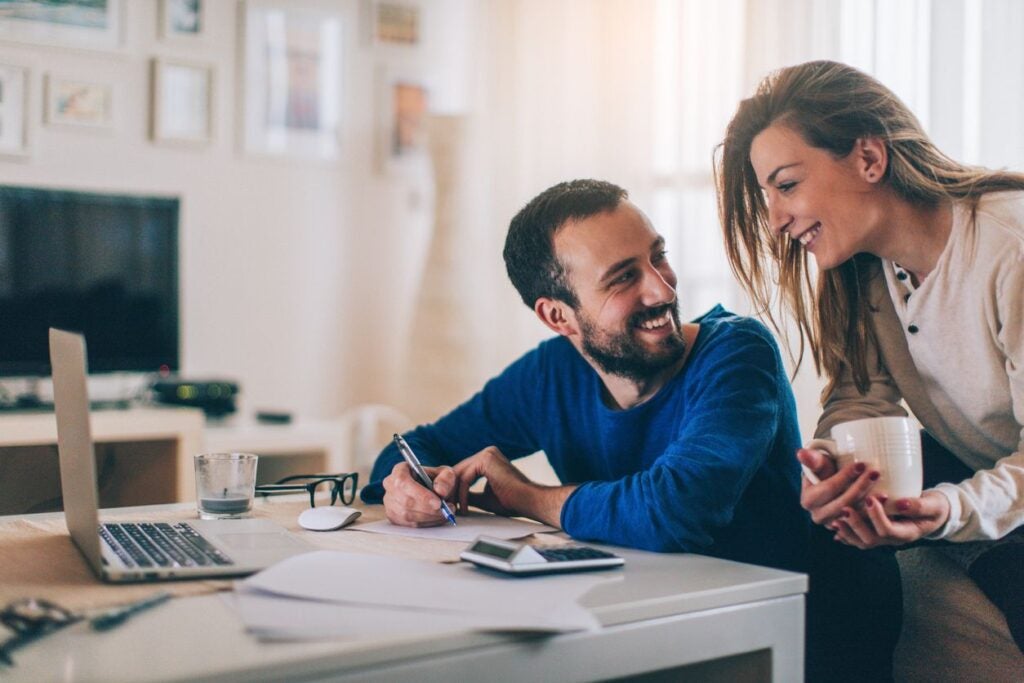 Couple sitting in their living room and checking their finances