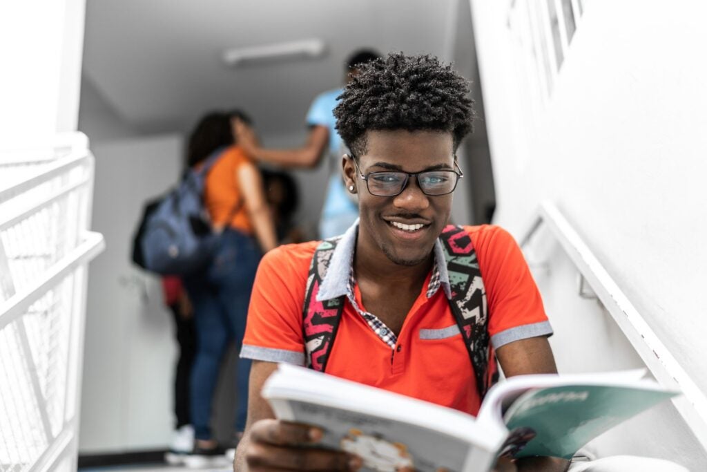 Student sitting and studying in the school's stairs