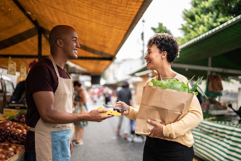 Woman using digital wallet to pay for groceries