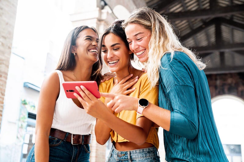 happy friends around a phone