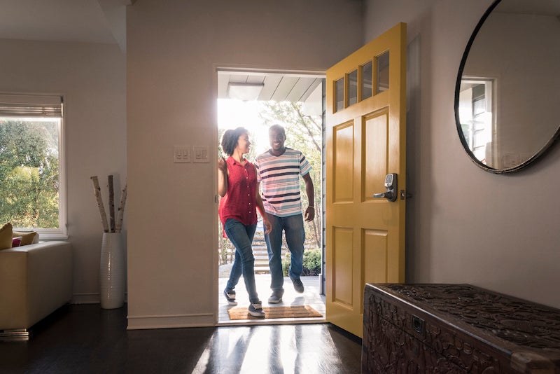 Couple walking into new home after getting mortgage