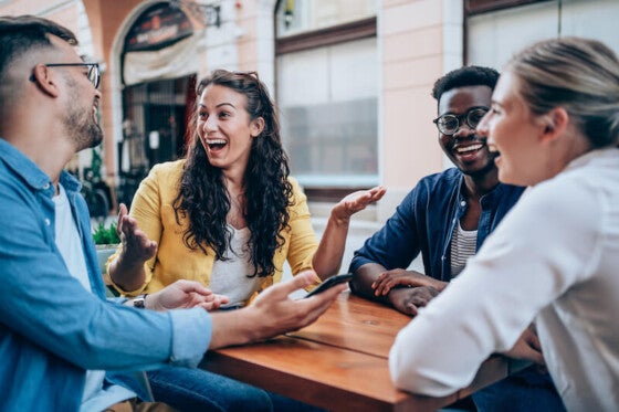 happy group of young adults at lunch earning cash back with bank account