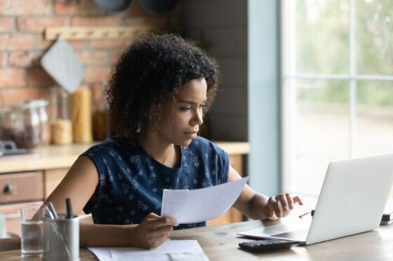 Young black woman sitting at counter looking at housing ratios.