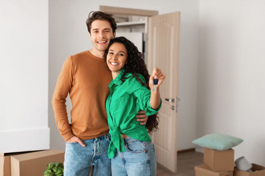Young first time home buyers in tennessee holding keys to new house.
