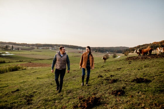 Young farmer couple walking in field