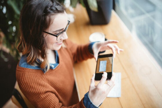 Young woman using mobile deposit to deposit a check into her bank account.