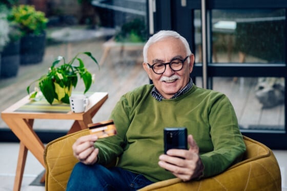 senior man looking at checking account that is earning rewards