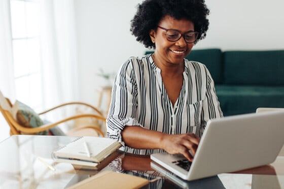 senior woman opening bonus rate checking account on her laptop