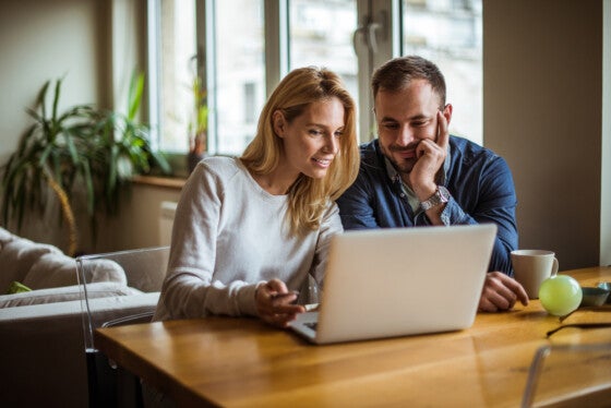 Couple looking at certificates of deposit online and weighing the pros and cons.