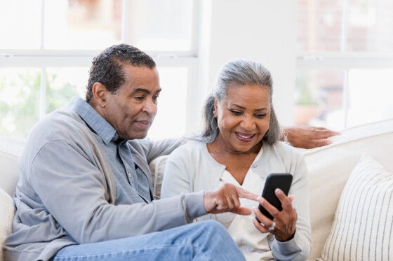 Older couple looking at differences between CDs vs Money market accounts on their phone.