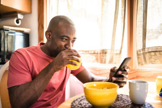 Man checking phone over breakfast