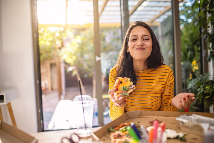 young woman eating a pizza bought with southeast bank checking account