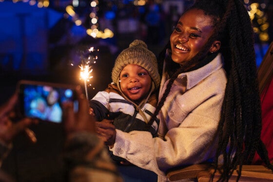 A man enjoys capturing a lovely moment of his son and wife playing with sparklers