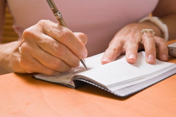Close up of a woman writing a check