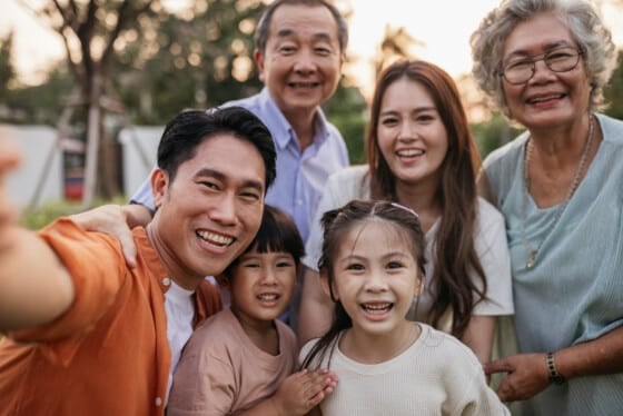 Smiling multigenerational family taking selfies in the yard