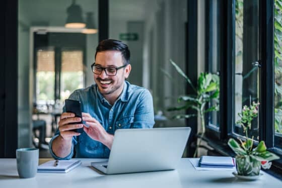 Man at work looking at online mobile banking app