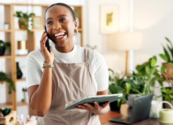 Black female business owner on phone in front of work station